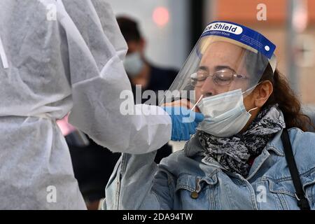 New York, États-Unis. 10 novembre 2020. Un travailleur de la santé administre un écouvillon nasopharyngé à une femme qui est testée pour le coronavirus sur un site mobile de test COVID-19 à travers Park, dans le quartier Queens de New York, NY, le 10 novembre 2020. Les États-Unis connaissent une augmentation du nombre de cas de COVID-19, qui a récemment dépassé 10 millions de personnes infectées par le coronavirus. (Anthony Behar/Sipa USA) crédit: SIPA USA/Alay Live News Banque D'Images