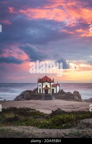 Coucher de soleil sur la plage avec une église sur la plage (Église de Senhor da Pedra) Banque D'Images