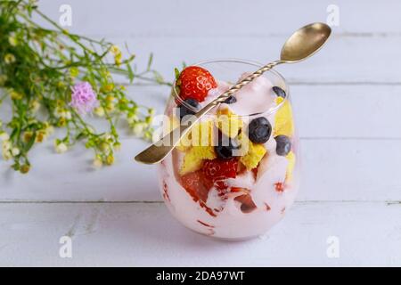 Pouding, gâteau et baies en glaas avec cuillère. Dessert à trois fles. Banque D'Images