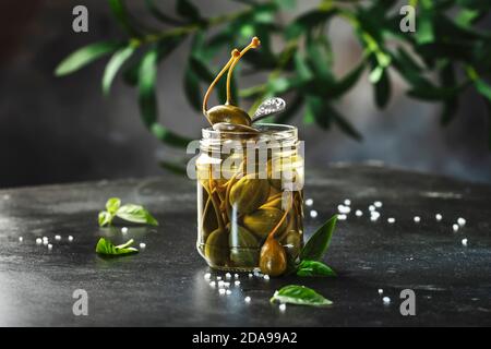 Fruits en conserve marinés ou marinés, marinés ou marinés, en gros plan dans un pot sur table de cuisine grise avec espace de copie Banque D'Images