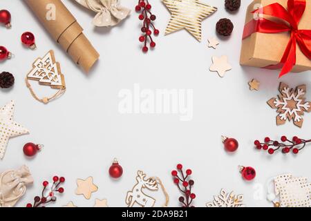 Magnifique cadre de Noël avec des décorations en verre, en textile et en bois, des cônes de pin, des sacs et une boîte de cadeaux, des baies sur fond de sarcelle. Vue de dessus de la pose à plat Banque D'Images