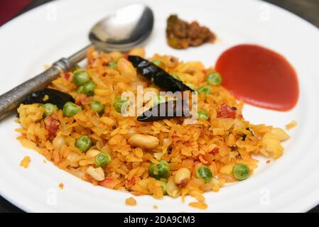 Aloo, Kanda Poha ou Tarri Pohe pickle épicé, sauce tomate repas populaire petit déjeuner indien en-cas Rajasthan, Delhi Inde. La cuisine indienne de rue battue le riz. Banque D'Images