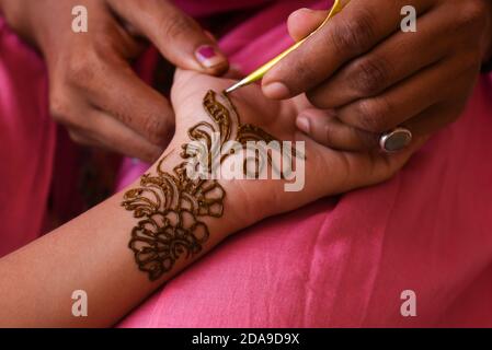 Artiste appliquant le beau henné tattoo arabe design à une femme de la mariée indienne sur le mariage dans Rajasthan. Le mehndi est populaire en Inde, au Pakistan Banque D'Images