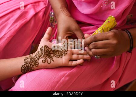 Artiste appliquant le beau henné tattoo arabe design à une femme de la mariée indienne sur le mariage dans Rajasthan. Le mehndi est populaire en Inde, au Pakistan Banque D'Images