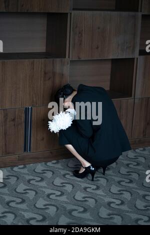 Pleurer avec des fleurs aux funérailles Banque D'Images