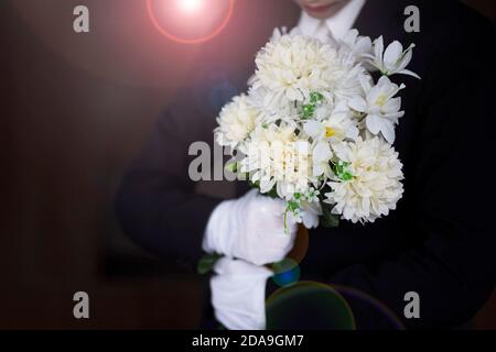 Deuil tenant des fleurs aux funérailles Banque D'Images