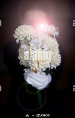 Deuil tenant des fleurs aux funérailles Banque D'Images