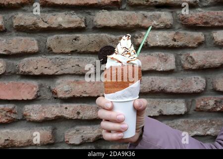 Femme tenant Trdelnik avec de la crème glacée dans l'ancien Tbilissi Banque D'Images