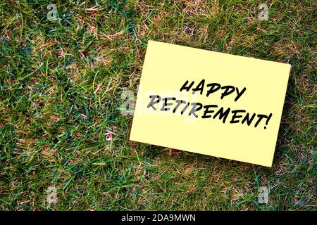 Message de bonne retraite écrit sur papier jaune sur fond d'herbe verte. Banque D'Images
