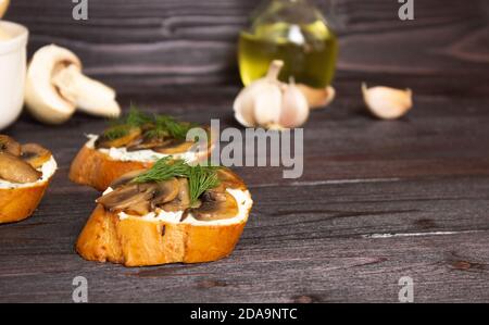 Bruschetta. Sandwichs aux champignons sur une planche en bois. Vue latérale fermée. Les produits ne sont pas mis au point en arrière-plan, espace libre pour le texte. Déliciou sain Banque D'Images