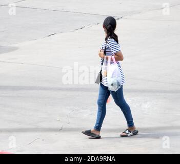 SAMUT PRAKAN, THAÏLANDE, JUIN 30 2020, UNE femme marche dans la rue et tourne en arrière Banque D'Images