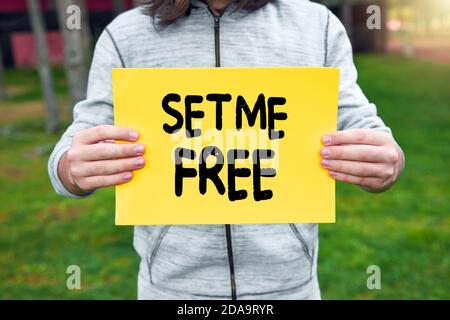 Un garçon adolescent tient une bannière jaune avec set Me Free text contre fond de nature. Liberté et indépendance dans la puberté. Banque D'Images