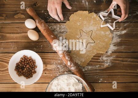 Préparation de biscuits façonnés à partir de pâte crue sur le panneau en bois. Vue du dessus Banque D'Images