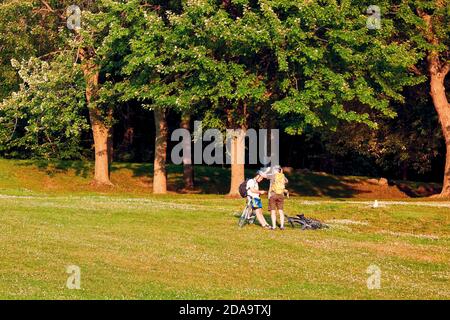 Montréal, Canada - juin 2018 : deux jeunes amis masculins canadiens ont une conversation avec leurs bicyclettes dans le parc du Mont-Royal, à Montréal, au Canada. Banque D'Images