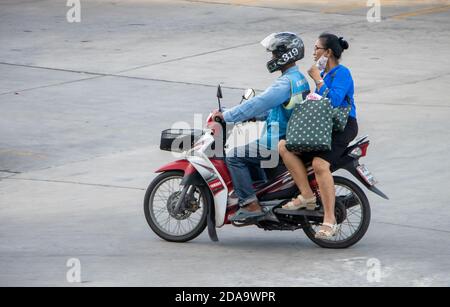 SAMUT PRAKAN, THAÏLANDE, JUIN 30 2020, UN chauffeur de taxi sur une moto se déplace avec une femme. Le chauffeur de moto-taxi transporte un passager. Banque D'Images