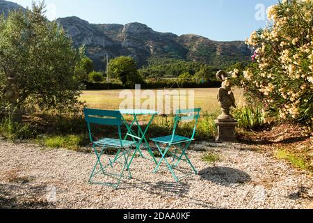 Ensemble de table et deux chaises bleues dans le jardin avec vue imprenable sur la montagne. Provence France. Banque D'Images