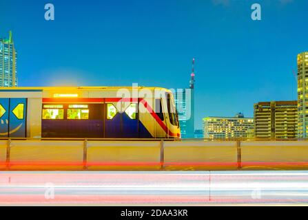 BTS Sky train sur fond de paysage urbain et des sentiers de circulation légers se déplaçant le soir et après le travail, Bangkok, Thaïlande Banque D'Images