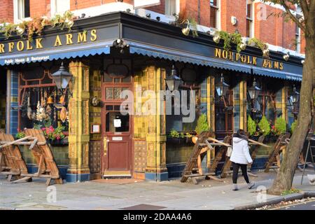 Une femme passe devant un pub et un restaurant fermés dans le centre de Londres pendant le second confinement national en Angleterre. Banque D'Images