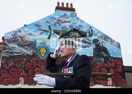 Eric Howden BEM, 76 ans, président de la Légion britannique de Redcar, qui a servi avec le corps royal de l'Ordnance, devant une fresque commémorative de la guerre à Redcar, dans le North Yorkshire, devant un silence de deux minutes pour se souvenir des morts de la guerre le jour de l'armistice. Banque D'Images