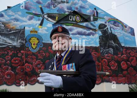 Eric Howden BEM, 76 ans, président de la Légion britannique de Redcar, qui a servi avec le corps royal de l'Ordnance, devant une fresque commémorative de la guerre à Redcar, dans le North Yorkshire, devant un silence de deux minutes pour se souvenir des morts de la guerre le jour de l'armistice. Banque D'Images