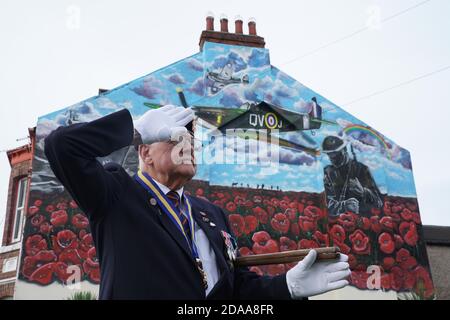 Eric Howden BEM, 76 ans, président de la Légion britannique de Redcar, qui a servi avec le corps royal de l'Ordnance, devant une fresque commémorative de la guerre à Redcar, dans le North Yorkshire, devant un silence de deux minutes pour se souvenir des morts de la guerre le jour de l'armistice. Banque D'Images