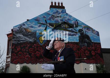 Eric Howden BEM, 76 ans, président de la Légion britannique de Redcar, qui a servi avec le corps royal de l'Ordnance, devant une fresque commémorative de la guerre à Redcar, dans le North Yorkshire, devant un silence de deux minutes pour se souvenir des morts de la guerre le jour de l'armistice. Banque D'Images