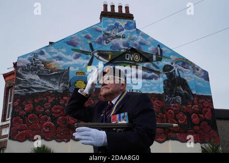 Eric Howden BEM, 76 ans, président de la Légion britannique de Redcar, qui a servi avec le corps royal de l'Ordnance, devant une fresque commémorative de la guerre à Redcar, dans le North Yorkshire, devant un silence de deux minutes pour se souvenir des morts de la guerre le jour de l'armistice. Banque D'Images