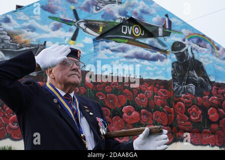 Eric Howden BEM, 76 ans, président de la Légion britannique de Redcar, qui a servi avec le corps royal de l'Ordnance, devant une fresque commémorative de la guerre à Redcar, dans le North Yorkshire, devant un silence de deux minutes pour se souvenir des morts de la guerre le jour de l'armistice. Banque D'Images