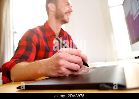 Portrait d'un concepteur d'âge moyen travaillant sur un bureau avec un stylet stylo Banque D'Images