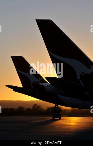 Silhoueté queues de avions de ligne au coucher du soleil à un aéroport, Banque D'Images