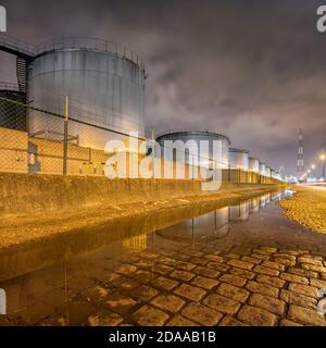 Scène nocturne avec un grand silo et un dépassement de pipeline à l'usine de production pétrochimique, Port d'Anvers. Banque D'Images