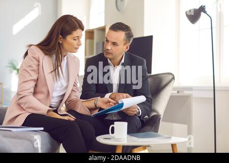 Un couple d'affaires analyse des documents sur le nouveau projet de travail pendant la pause-café. Banque D'Images