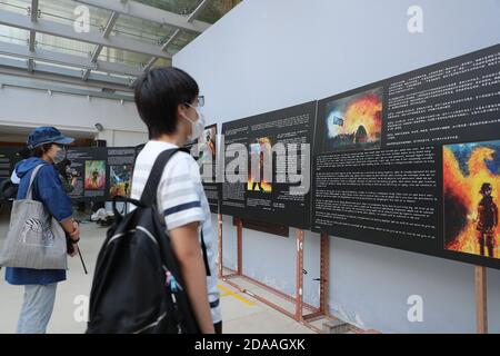 Les personnes qui portent un masque facial sont vues en regardant des photos de protestation à l'Université chinoise de Hong Kong (CUHK).UNE exposition de photos tenue à l'Université chinoise de Hong Kong (CUHK) exhortant les gens à ne pas oublier la bataille menée entre les manifestants pro-démocratie et les forces de police pro-gouvernementales de l'université campus l'année précédente. Banque D'Images