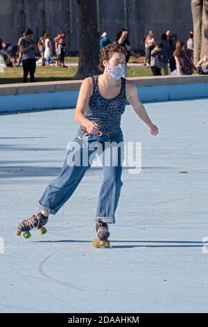 Une jeune femme dans un rouleau masque skate autour de la Unisphere dans le parc de Flushing Meadows Corona à Queens, New York. Banque D'Images