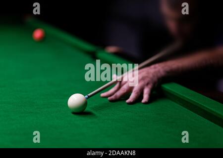 Homme essayant de frapper la balle dans le billard. Mise au point peu profonde. Banque D'Images