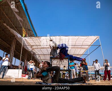 une fille interprète des acrobaties de rue et un spectacle de rue pour de l'argent au festival de chameau de pushkar. Banque D'Images
