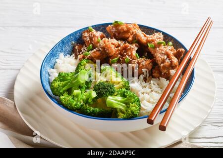 Poulet du général TSO en-cas chinois croustillants dans un bol avec du riz et des bouquets de brocoli vapeur, vue horizontale depuis le dessus Banque D'Images