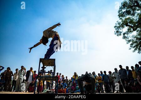 une fille présente des acrobaties de rue et un spectacle de rue au festival de chameau de pushkar. Banque D'Images