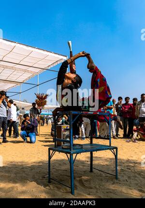 une fille exécute des acrobaties de rue en équilibrant la bouteille à la tête au festival de chameau de pushkar. Banque D'Images