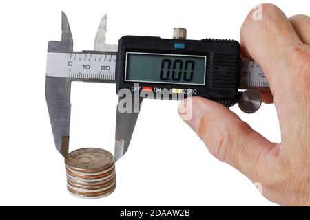 Pile de pièces de monnaie mesurée avec un marqueur dans la main de man. Isolé sur blanc. Banque D'Images