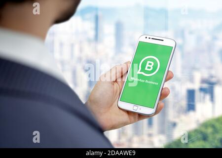 ROSARIO, ARGENTINE - 11 NOVEMBRE 2020 : application d'entreprise WhatsApp sur l'écran du smartphone. Jeune homme d'affaires avec un téléphone portable blanc dans la main. Banque D'Images