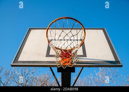 Basket-ball de rue à une journée ensoleillée avec ciel bleu en arrière-plan. Jeu de jeunes urbain. Concept de succès, points de notation et de victoire Banque D'Images