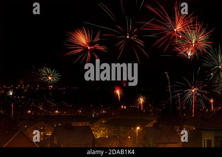 Feux d'artifice au-dessus d'une ville à la veille du nouvel an Banque D'Images