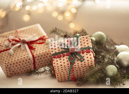Gros plan de cadeaux de noël magnifiquement emballés sur fond flou de lumières floues. Banque D'Images