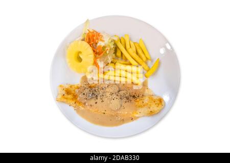 Steak de poisson isolé avec frites et salade dans une assiette blanche sur fond blanc avec passe-cheveux. Banque D'Images