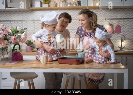 La mère de famille, la grand-mère et les deux sœurs cuisinent dans la cuisine. Banque D'Images