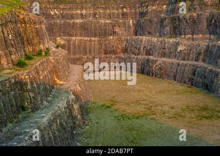 Bancs abrupts de calcaire excavé dans la carrière abandonnée d'Eldon Hill, entre Castleton et Peak Forest, en plein soleil le soir, en regardant vers l'est. Banque D'Images