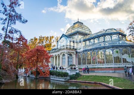 Le Crystal Palace dans le parc Retiro de Madrid avec un paysage automnal et une journée un peu nuageux au coucher du soleil. Arbres aux couleurs d'automne et lumière d'automne. Banque D'Images