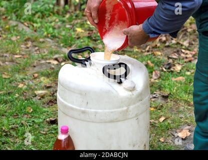 Le fruitier verse le jus pressé des pommes dans le canon Banque D'Images