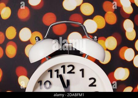 Gros plan sur le réveil rétro avec lumières bokeh floues Banque D'Images